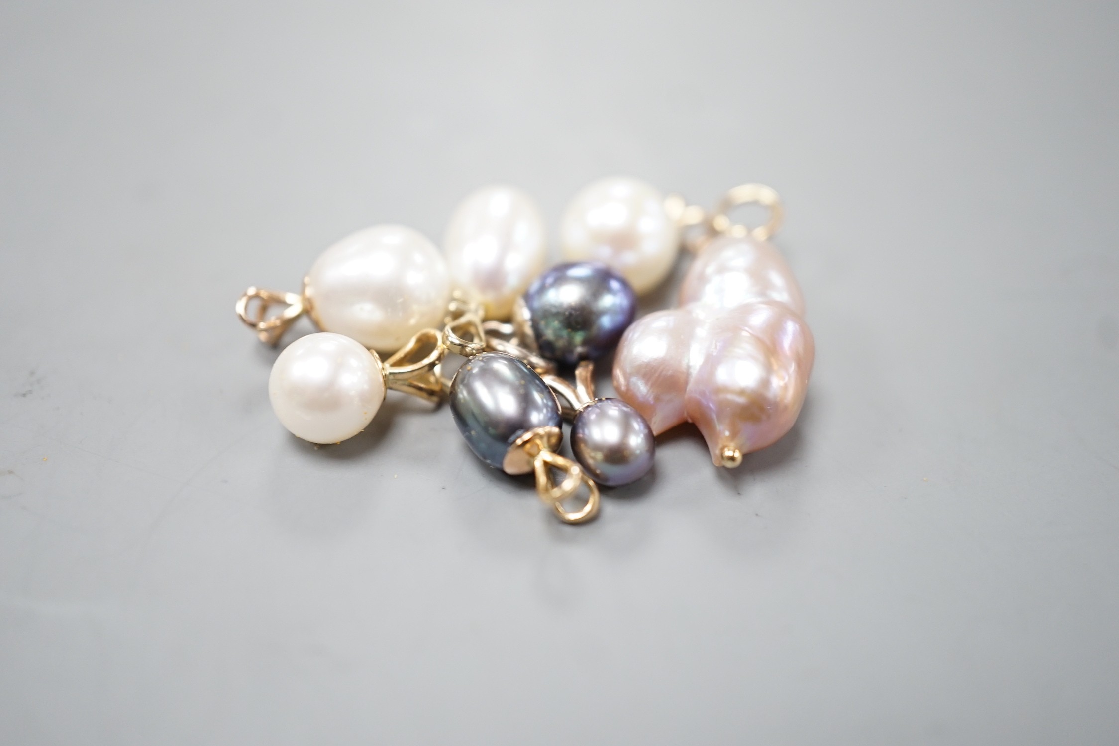 Seven assorted modern yellow metal mounted cultured pearl pendants and a similar white metal mounted pendant, largest 23mm.